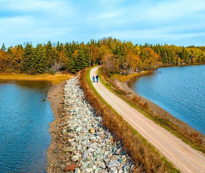 A view of 2 people walking in western Cape Breton Island following a traffic-free trail - flat and very easy with Freewheeling Adventures.