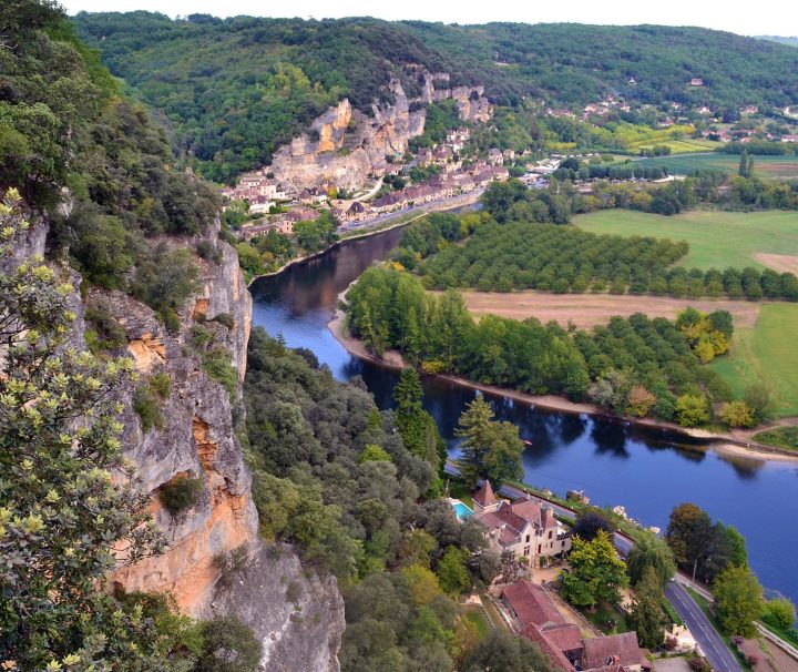 A cliff with buildings neatly nestled into the cliff face, blending with the landscape near Rocamadour on the Dordogne Valley Bike or Walking Tour with Freewheeling Adventures.