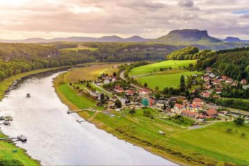 The image shows a scenic view of the Elbe River meandering through the Saxon Switzerland National Park in Germany