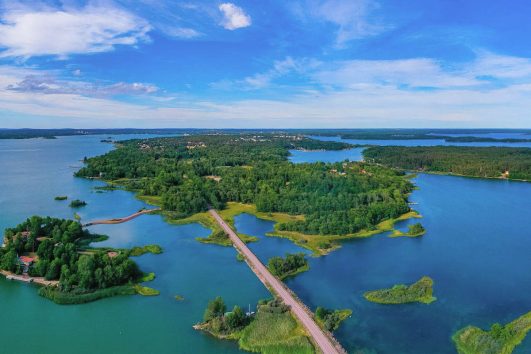 This aerial view captures a scenic road connecting islands in the Åland Archipelago in Finland