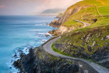 This image depicts a scenic coastal drive along the Dingle Peninsula in County Kerry, Ireland