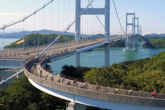 This image depicts a moment on the Shimanami Kaidō, a famous cycling route in Japan that spans the Seto Inland Sea
