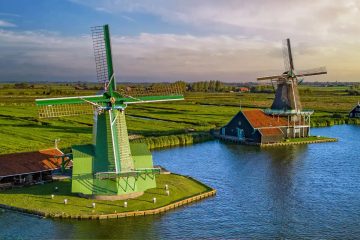 The image features the iconic Zaanse Schans windmills located in the Netherlands