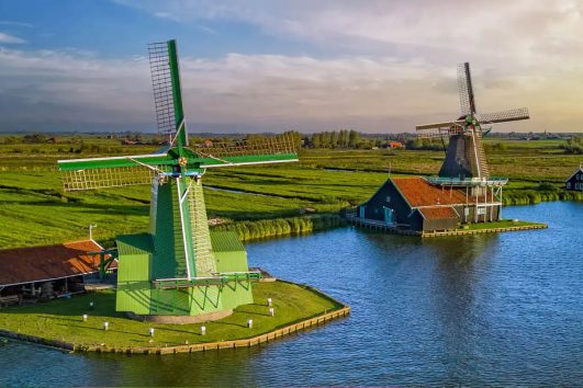 The image features the iconic Zaanse Schans windmills located in the Netherlands